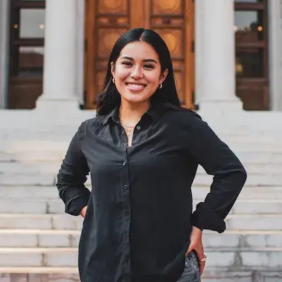 Woman in black blouse standing outside in front of stairs to a building
