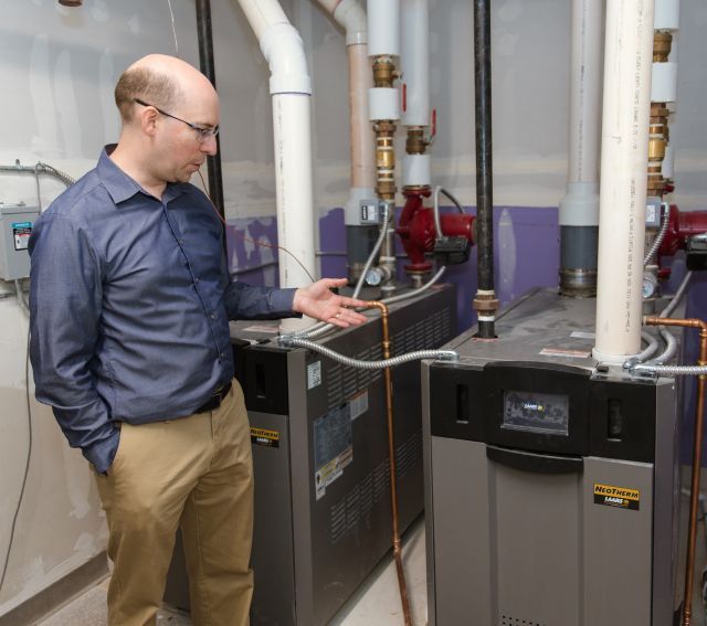 Man gestures at high-performance boiler