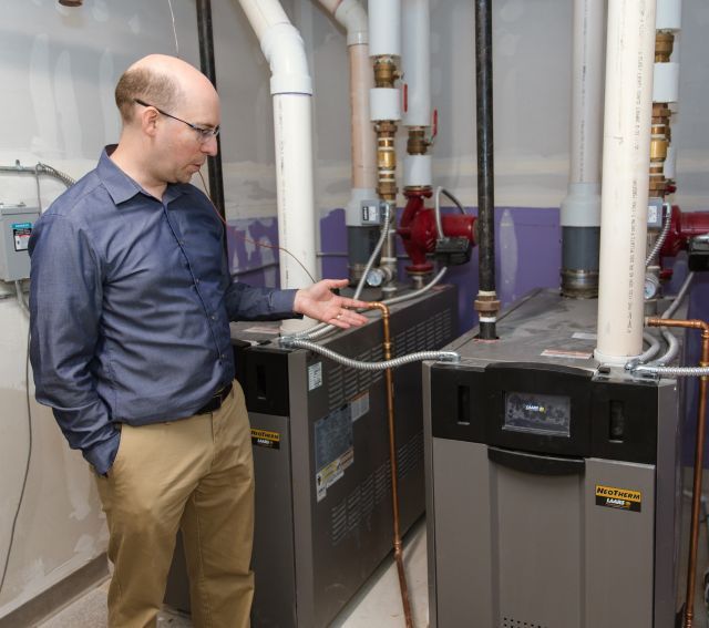 Man gestures at high-performance boiler 