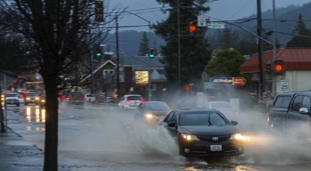 Cars driving through a flooded street in Ukiah, California