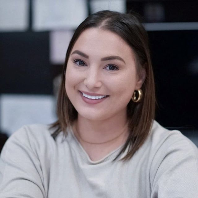 Person smiling with shoulder length dark hair