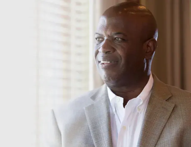 Person in light colored suit jacket and white shirt 