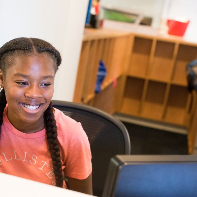 teenage girl sitting in front of a computer