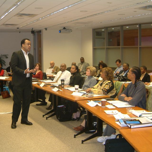 A man presenting in the front of the room during a training session