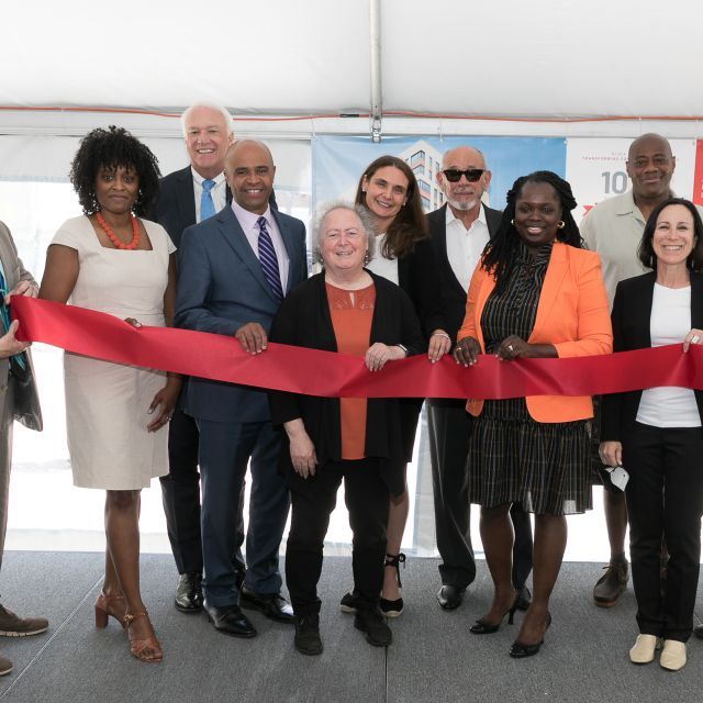 Group of people standing at a ribbon cutting