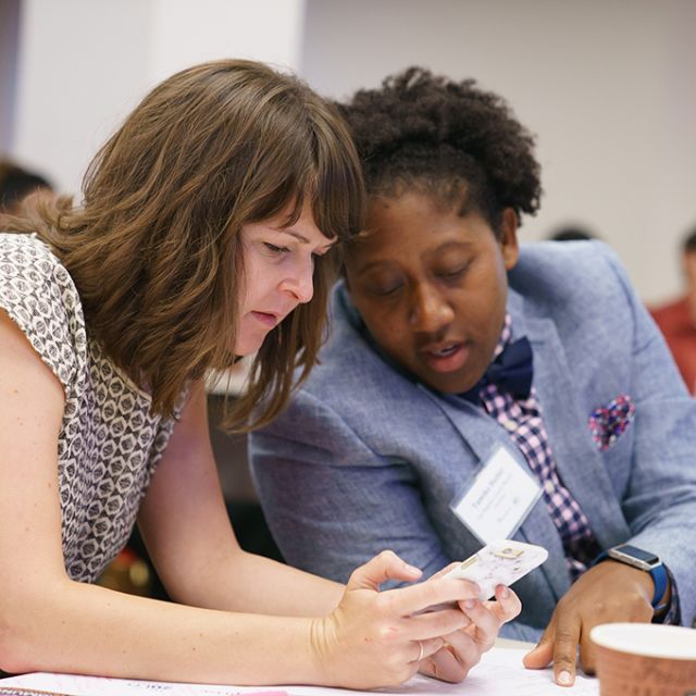 Two people share notes during a session