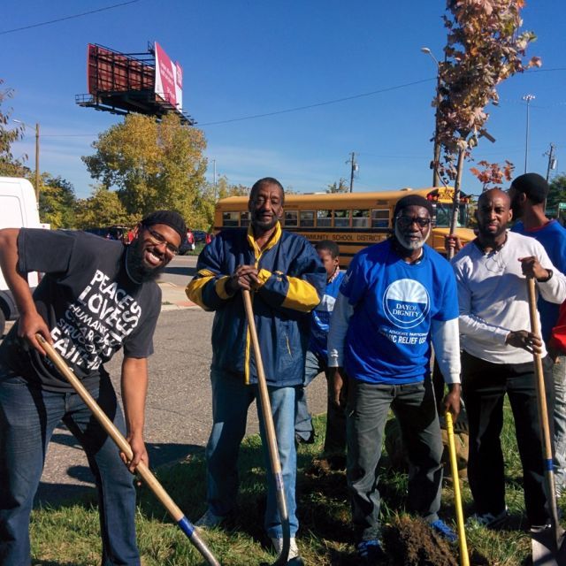 A group of volunteers with shovels posing for a photo