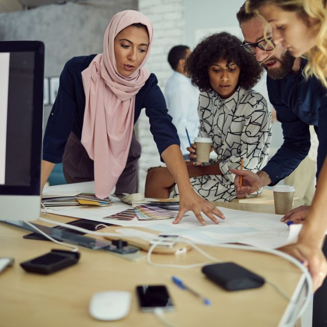 People working in an office around a desk