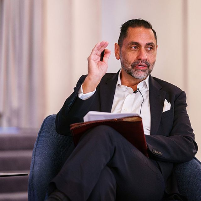 Carlos Martin, program director of Remodeling Futures at Harvard Joint Center for Housing Studies, sitting in a chair and speaking