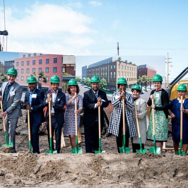 A group lined up with shovels and hard hats for a ground-breaking