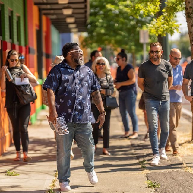A group of people walking down the sidewalk laughing