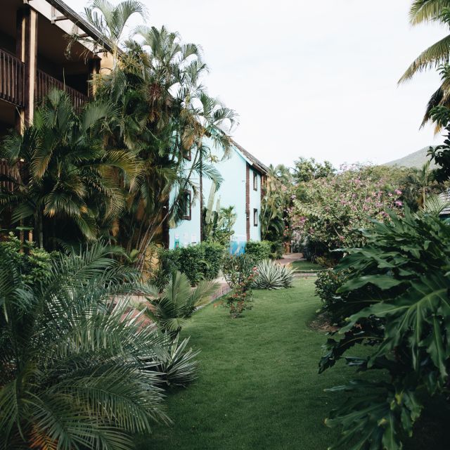 Two story apartment building in development with palm trees and other foliage