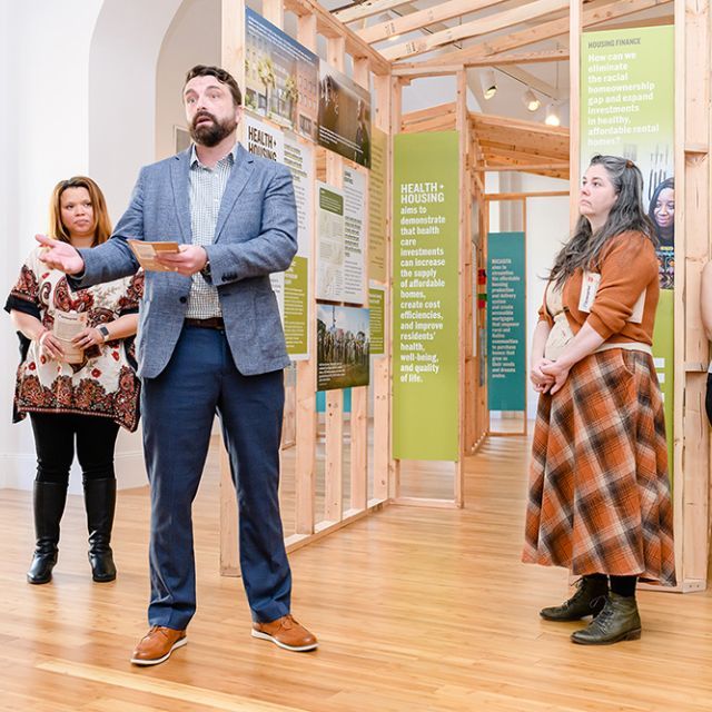 A man presenting exhibit information to a group of people