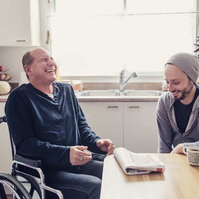 Men laughing at kitchen table