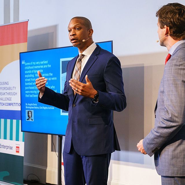 A person in a suit giving a presentation