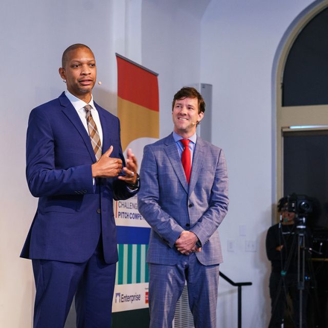 Two men giving a presentation in suits