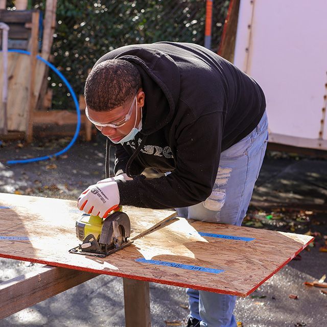 A person cutting wood with a table saw