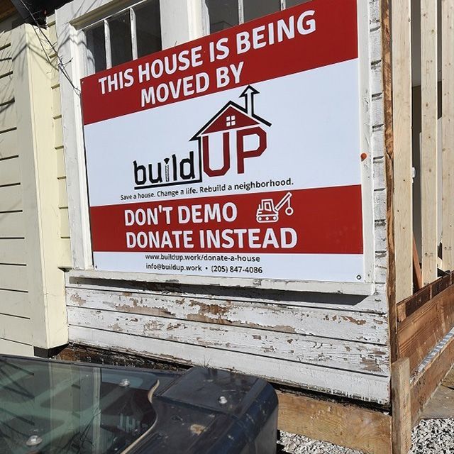 A sign "This house is being moved by build UP" sign