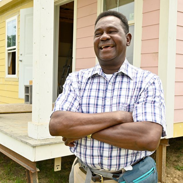 A man smiling with his arms crossed