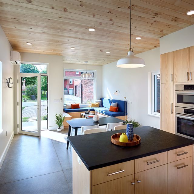 The interior view of a kitchen, living room, and front door