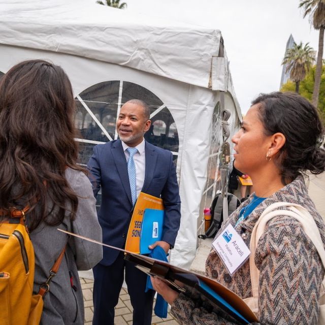 Man in suit shaking hands with a woman who has back to camera