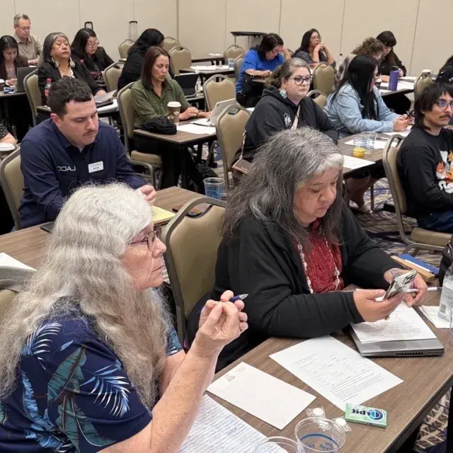 Participants at the Tribal Housing Academy seated at rows of tables