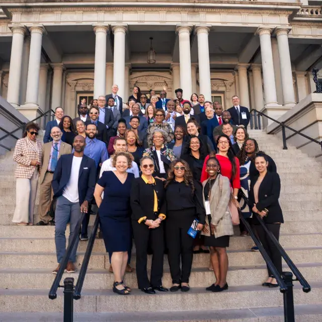 Group of people standing on the steps of a government building