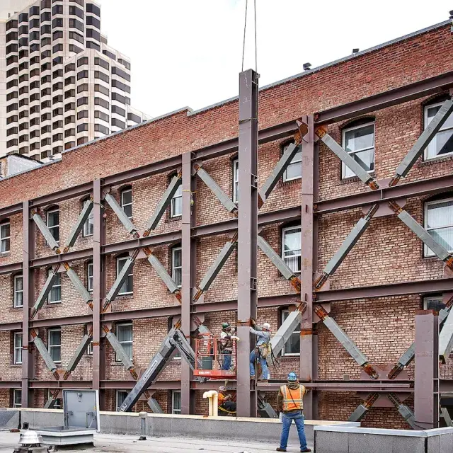 Men working on red brick and steel building