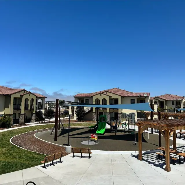 Apartments at Escalante Meadows with a playground and sitting area in the foreground 