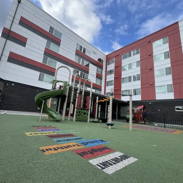 Skyward view of a children's playground at a 5-story apartment building
