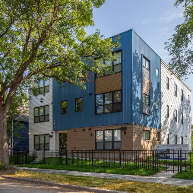 Tree-lined street with mix of small multifamily building adjacent to single-family homes