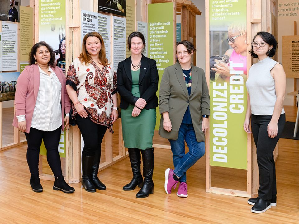 Five people standing in row of an exhibit