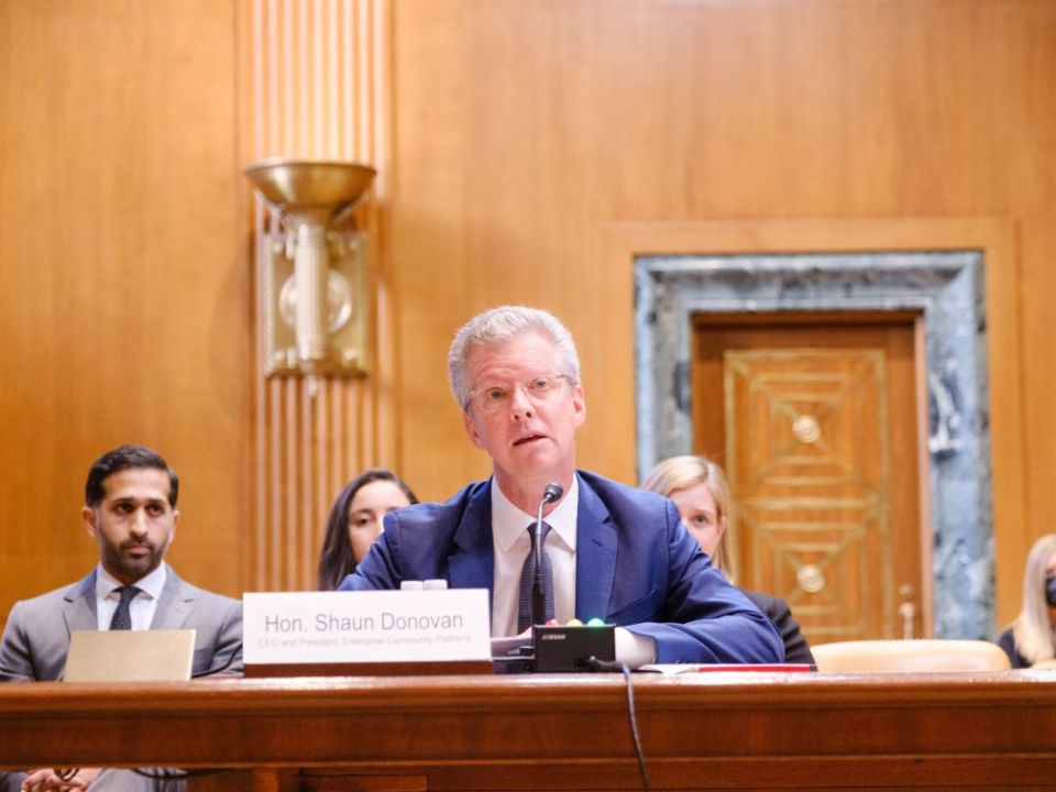 Shaun Donovan, CEO and president, at a conference table with people seated in the background