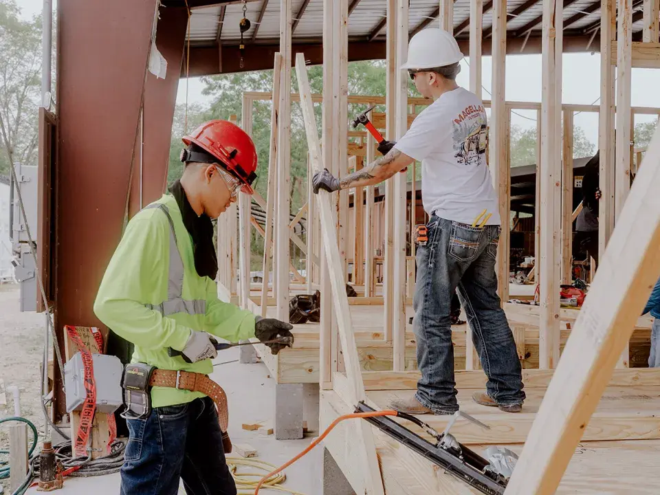 Two men in hard hats working on ta construction site