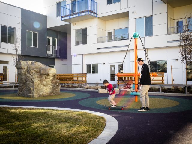 man watching a boy on a skateboard at a playground