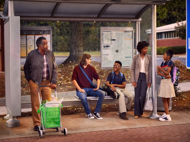 Multi-generational people waiting at bus stop