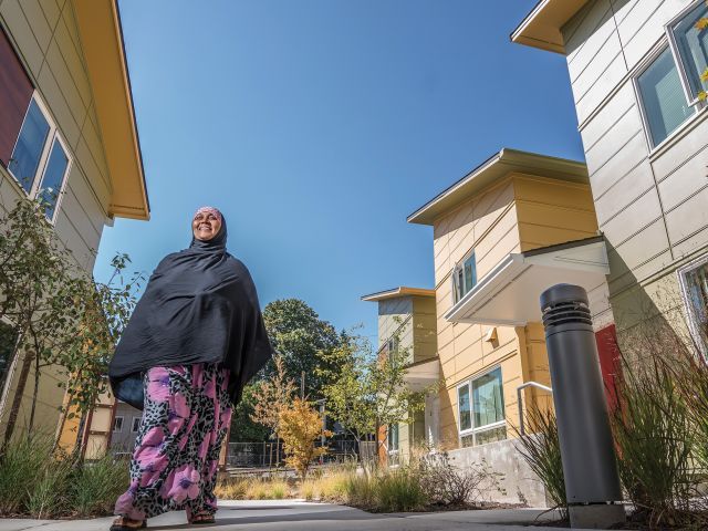 Woman walking on a sidewalk through a residential community