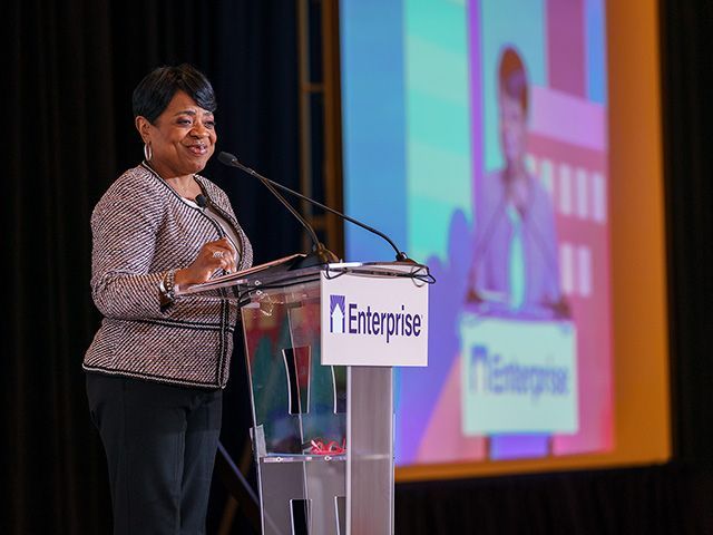 Lori Chatman standing at a podium speaking