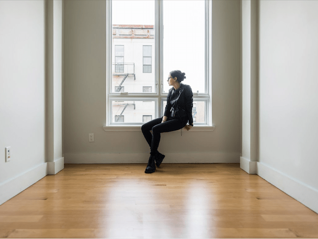 Woman sitting in a room on window ledge