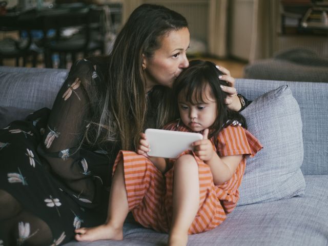 Mom kissing daughter