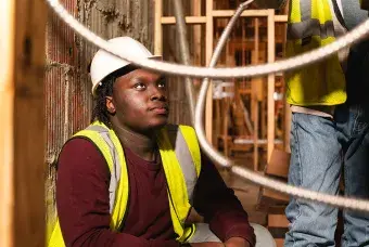 A construction worker wearing a hard hat and looking up